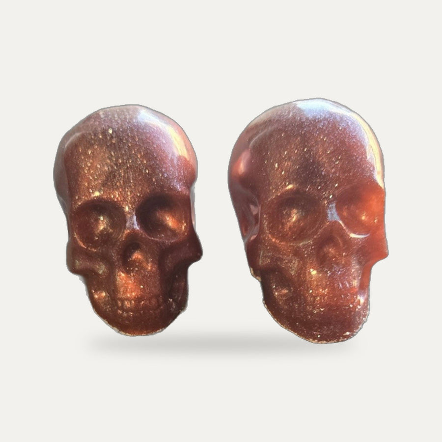 Pair of copper metallic resin skulls