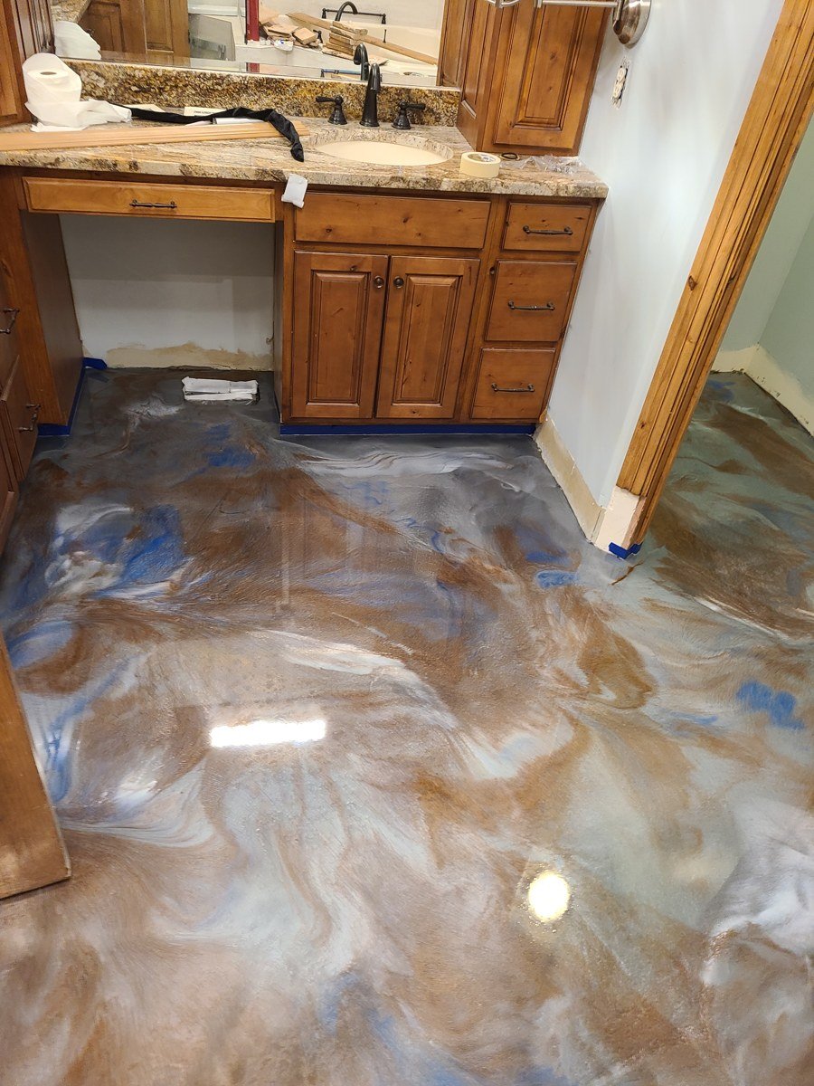 Residential bathroom with a swirled bronze, pearl, and blue metallic floor
