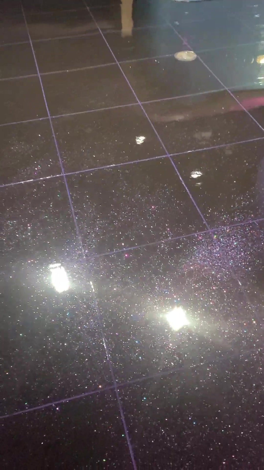 Black glitter metallic floor sparkling under lights