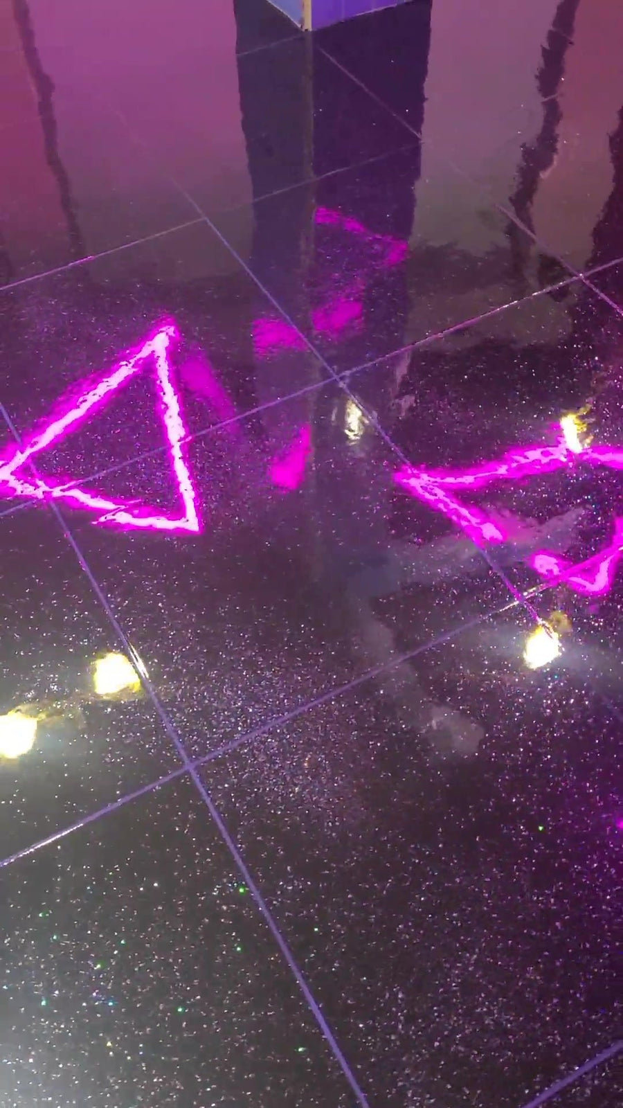 Black glitter metallic floor reflecting neon lights